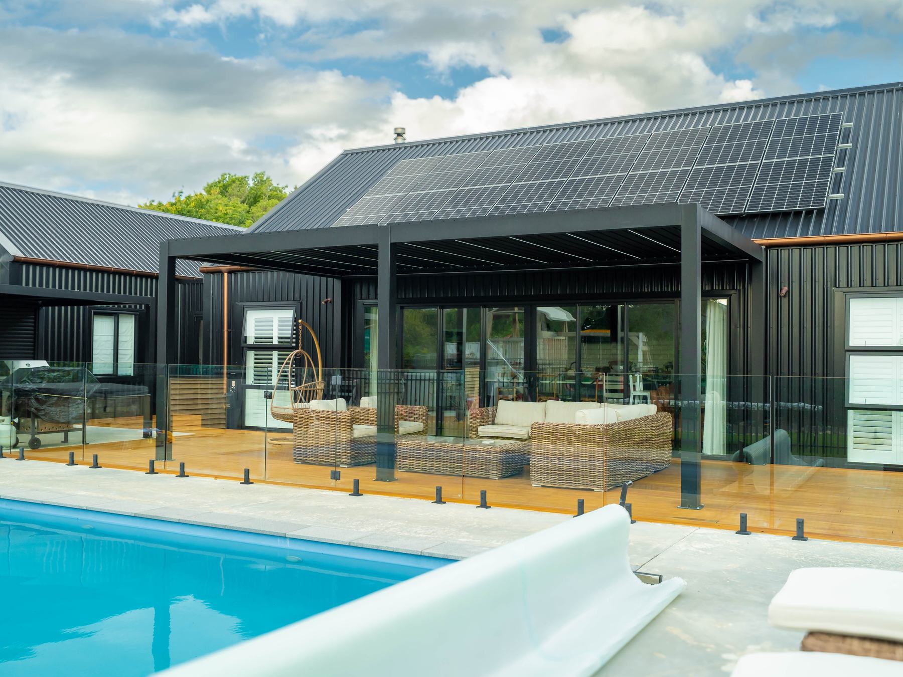 Opening louvre pergola over a poolside lounge